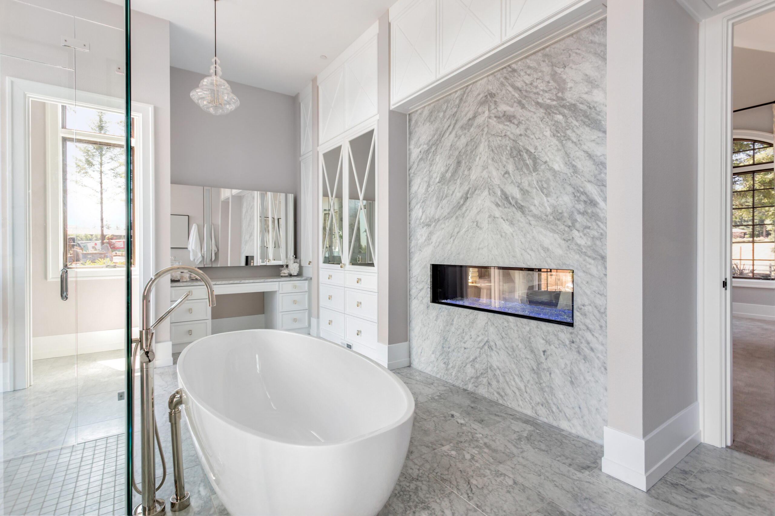 Luxurious Master Bathroom in New Home with Fireplace and Large Bathtub